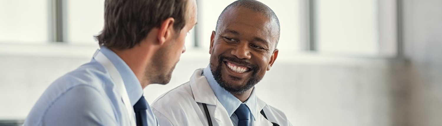 Side view of a doctor talking to a man in dress shirt
