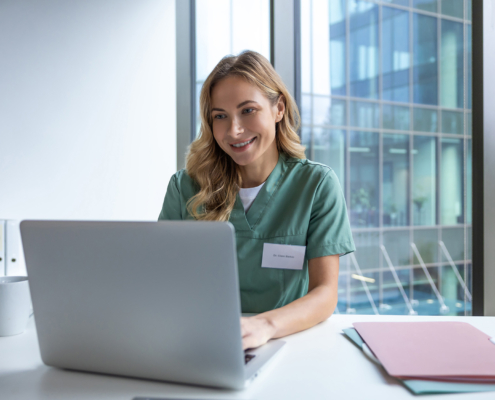 Woman doctor in hospital working with computer preparing medical documents