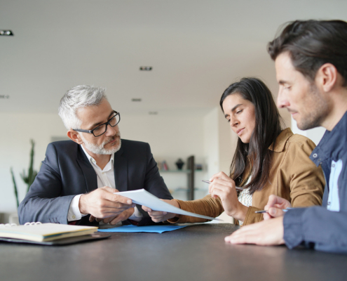 couple signing contract with real-estate agent in contemporary house