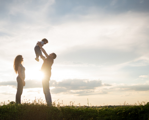 family mom dad and little son walk at sunset