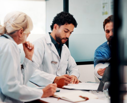 Hospital, meeting and doctors with documents in boardroom for funding